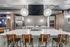 Contemporary kitchen featuring a sleek marble island with stylish wooden chairs, modern cabinetry, and striking geometric backsplash, perfect for entertaining.