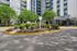 Inviting apartment complex entrance with lush landscaping and modern architecture, showcasing a welcoming urban living environment.