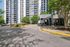 Modern and inviting apartment complex entrance with lush landscaping, offering a welcoming atmosphere and stylish architecture.