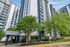 Modern high-rise apartment building with sleek architecture, lush greenery, and welcoming entrance marked by 'Arrive' sign.