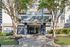 Inviting apartment entrance with modern design, beautiful landscaping, and a paved walkway.