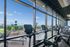 Modern fitness center with panoramic city views, featuring state-of-the-art exercise bikes and abundant natural light.