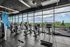 Modern fitness center with panoramic city views, featuring state-of-the-art exercise equipment and floor-to-ceiling windows.