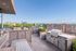 Stunning rooftop terrace featuring modern grill area, stylish seating, and panoramic city views.