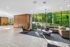 Modern apartment lobby with floor-to-ceiling windows, plush seating, and chic lighting offering a welcoming ambiance and scenic outdoor views.