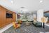 Modern apartment lobby with stylish leather seating, elegant wooden walls, and artistic lighting.