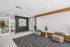Modern apartment lobby with stylish zebra-patterned chairs, elegant decor, and a wave-textured feature wall.