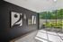 Elegant apartment lobby featuring modern black and white wall art with large windows overlooking lush greenery.