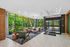 Chic lobby area with modern seating, large windows showcasing lush greenery, and elegant decor for a welcoming atmosphere.