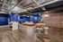 Modern lounge with sleek hardwood floors, bold blue walls, and chic seating areas perfect for relaxation or entertainment.