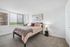 Inviting bedroom with modern decor, featuring a cozy double bed, ambient lighting, and a large window offering serene views.