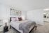Elegant bedroom with a plush queen-sized bed, stylish decor, and an en-suite bathroom, showcasing contemporary living at its finest.