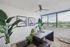 Bright home office with modern design, large window with city view, lush green plants, and abstract art on the wall.