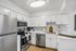 Contemporary kitchen with sleek stainless steel appliances, elegant white cabinetry, and stylish subway tile backsplash.