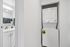 Compact laundry area with a modern stackable washer and dryer next to a stylish bathroom featuring contemporary fixtures and plush towels.