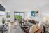Bright, modern living room with stylish decor, plush sofa, and large windows offering stunning city views.