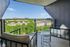 Chic balcony view featuring modern seating and a stunning panorama of lush greenery and cityscapes.