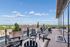 Stunning rooftop terrace with stylish seating, offering panoramic views of the city skyline and lush greenery.