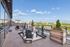 Luxurious rooftop terrace with stylish wooden decking, elegant seating, and stunning city skyline views.