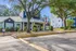Inviting leasing center with charming facade, surrounded by lush greenery and mature trees, perfect for prospective residents.