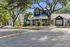 Charming leasing center surrounded by lush greenery and ample parking, showcasing inviting architecture with a modern metal roof.