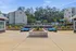Beautiful outdoor area with modern seating, lush landscaping, and a vibrant pool setting against a backdrop of stylish apartment buildings.