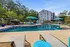 Inviting apartment complex pool area with stylish loungers, shaded seating, and lush greenery, perfect for relaxation and socializing.