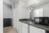 Modern kitchenette featuring sleek countertop, compact microwave and ample storage space, perfect for an efficient living experience.