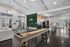Luxurious community room with sleek shuffleboard table, modern seating, and stylish kitchen area featuring stainless steel appliances.