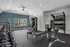 Modern fitness center with state-of-the-art equipment, free weights, and ample natural light, perfect for energized workouts.