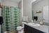 Chic and modern bathroom featuring a stylish green patterned shower curtain, sleek vanity, and elegant fixtures.