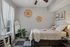 Cozy bedroom with modern decor features a comfortable bed, elegant wall art, a stylish mirror, and lush greenery for a tranquil living space.