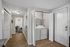 Bright hallway in modern apartment with in-unit laundry, laminate flooring, and sleek white doors opening to a cozy living space.