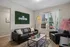 Inviting living room with chic leather sofas, vibrant wall art, and large window offering abundant natural light.