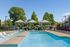 Inviting outdoor pool area with shaded cabanas, modern lounge chairs, and vibrant sunny ambiance, perfect for relaxation.