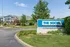Charming community entrance of The Social Edwardsville, featuring modern architecture and lush greenery on a sunny day.