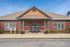 Inviting leasing office with a charming brick exterior, welcoming entrance, and lush greenery surrounding the property.