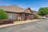 Charming brick leasing office surrounded by manicured landscaping and ample parking for a welcoming first impression.