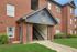 Charming brick apartment building with inviting entrance and lush landscaping.