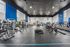 Spacious and modern gym featuring top-of-the-line exercise equipment, large windows for natural light, and sleek design.
