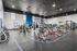 Expansive gym with state-of-the-art workout equipment, bright windows, and modern design.