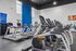 Modern fitness center with state-of-the-art cardio equipment, featuring sleek treadmills and vibrant blue accent wall, ideal for a dynamic workout experience.
