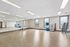 Bright fitness studio with sleek mirrors, modern equipment, and natural light enhancing the spacious workout area.