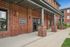 Charming brick exterior of an upscale fitness center, featuring elegant columned entrance and vibrant flower accents.