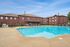 Inviting apartment complex featuring a sparkling swimming pool surrounded by stylish red brick buildings and well-maintained lounge areas.