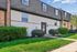 Charming townhouse exterior with lush green landscaping, modern architecture, and inviting entryway.