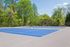 Vibrant outdoor tennis court surrounded by lush trees, offering a perfect space for sports enthusiasts.
