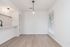 Modern apartment dining area featuring sleek wood flooring, ambient lighting, and a chic open kitchen design.