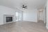 Bright and modern living room featuring a sleek marble fireplace, elegant wood flooring, and ample natural light from sliding glass doors.