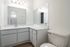 Sleek bathroom with modern vanity, large countertop, and bright lighting for a refreshing experience.